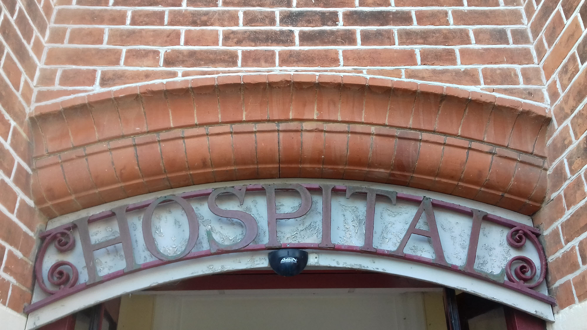 Original hospital sign over the front door of the building